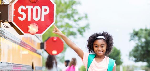 image of student pointing out stop sign on school bus